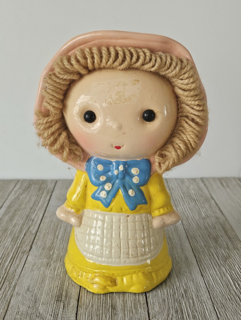 Vintage Ceramic 7" Little Girl Coin Bank with a Pink Bonnet, Yarn Hair, a Yellow